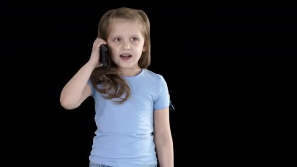 Kleines Schulmädchen, das beim Gehen mit dem Smartphone telefoniert, Alphakanal — Stockvideo
