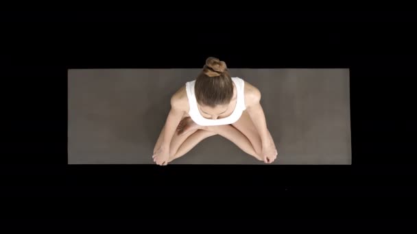 Young sporty woman practicing yoga sitting in lotus pose and breathing deeply, Alpha Channel — Stockvideo