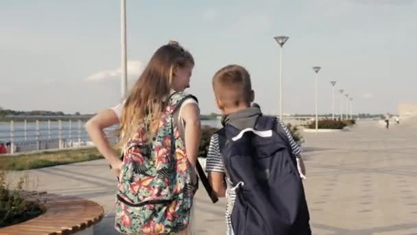 Anak perempuan dan anak laki-laki berjalan cepat ke sekolah terlambat . — Stok Video