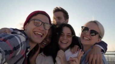 Yaz güneşinde selfie çeken gülümseyen öğrenciler.