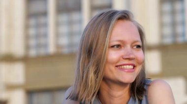 Çekici sarışın, güler yüzlü dışarıda dost canlısı oturuyor..