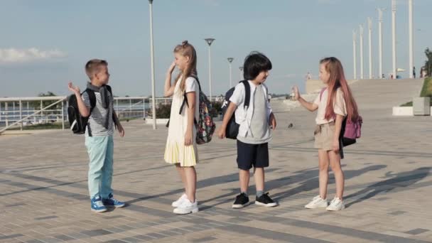 Schulfreunde treffen sich, geben High Five und gehen gemeinsam zur Schule. — Stockvideo