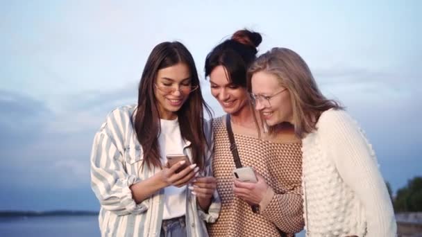 Mädchen amüsieren sich über etwas, das sie auf einem Handy sehen. — Stockvideo