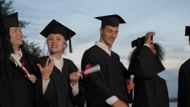 Studenti házet čepice do vzduchu chůze. — Stock video