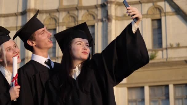 Absolwenci robiący selfie po ukończeniu studiów. — Wideo stockowe