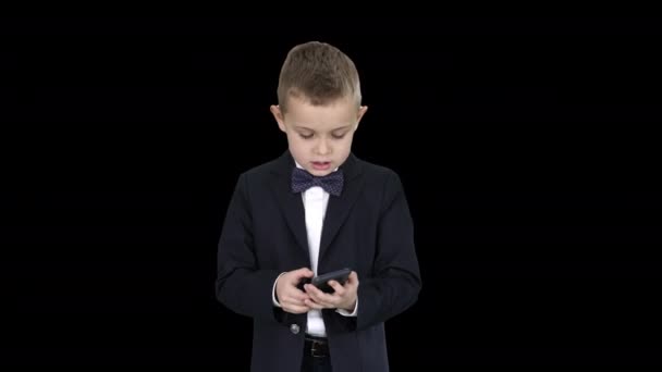 Menino pequeno em traje andando e usando smartphone, Alpha Channel — Vídeo de Stock