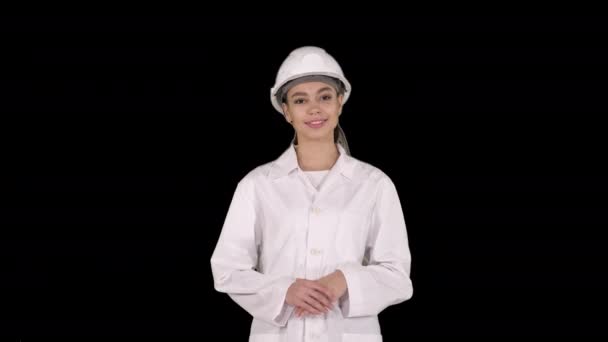 Sert şapkalı olgun mühendis kadın yürürken elleriyle ürünü veya metni gösteriyor, Alpha Channel. — Stok video