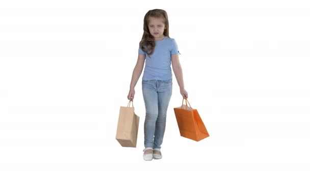 Kis lány bevásárló táskák séta a fehér háttér. — Stock videók