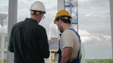 Mühendis ve işçi planlara bakıyor..