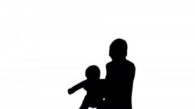 Siluet Anne ellerini bebeğini döndürür. Annelerin elinde uçan bebek.