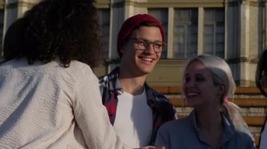 Çeşitli mutlu genç arkadaşlar el ele tutuşup beşlik çakıyor..