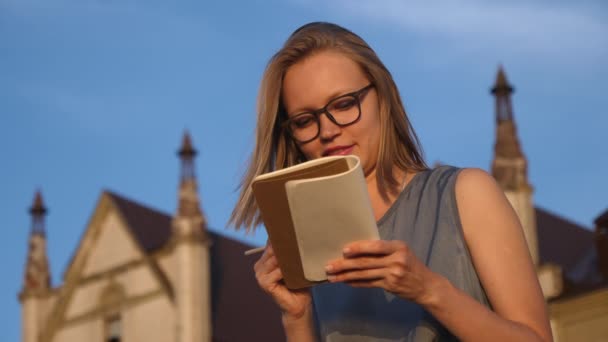 女学生は外で働きノートを作る. — ストック動画