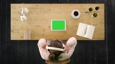 Masada oturan tabletten müzik dinleyen bir kız. Yeşil Ekran Modifiye Görüntüsü.