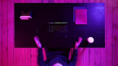 Neşeli genç oyuncu evde çalışan bir bilgisayar akışında video oyunları oynuyor.