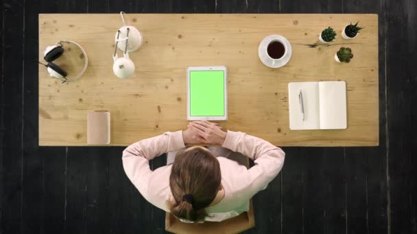 Nő alkalmi rózsaszín lóhere ül a tabletta előtt, és nyomja érintőképernyőn ujjal. Zöld képernyő Mock-up Display. — Stock videók