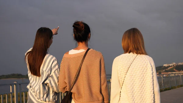 Grupp unga damer promenader och chatta längs strandpromenaden. — Stockfoto