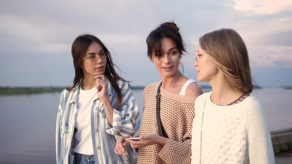 Felices amigas haciendo una búsqueda por voz en el teléfono inteligente y —  Fotos de Stock