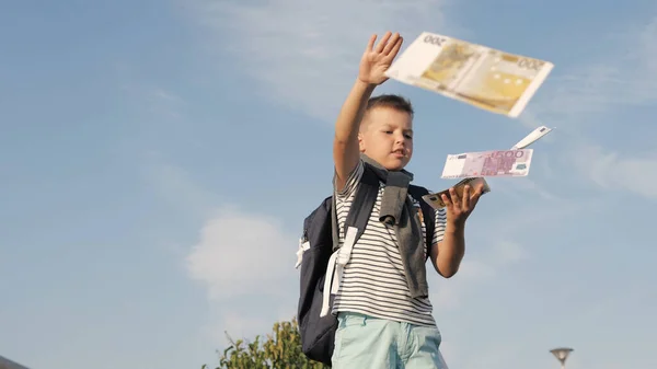 Маленький мальчик делает евро банкноты летать . — стоковое фото