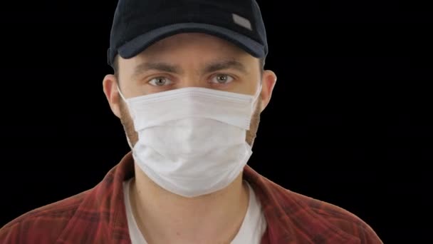 Fekete baseball sapkás férfi orvosi maszkkal az arcán, Alpha Channel. — Stock videók
