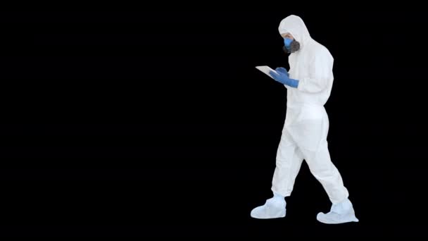 Tehlikeli madde giysisi giyen sağlık çalışanı dijital tablet üzerinde çalışıyor, Alpha Channel — Stok video
