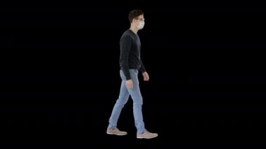 Tıbbi maskeli genç yakışıklı adam Alpha Channel 'da yürüyor.
