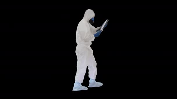 걸을 때 폐 x-ray 를 보고 있는 보호 슈트를 입고 있는 의사 알파 채널 — 비디오