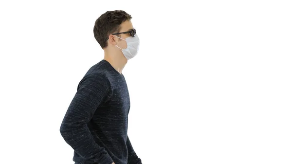 Joven ciego con bastón largo y máscara médica caminando sobre fondo blanco . —  Fotos de Stock