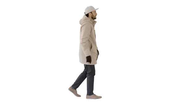 Красивый модный мужчина в зимнем стильном пальто ходит на белом фоне . — стоковое фото