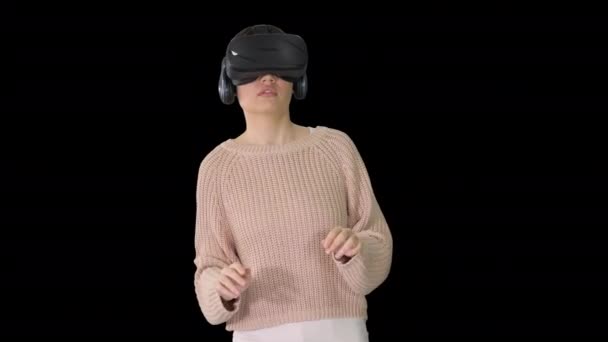 Linda mujer joven caminando y usando auriculares VR interactivos, Alpha Channel — Vídeo de stock