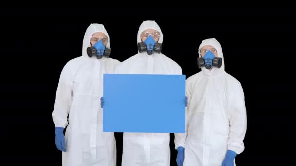 Три врача в защитных костюмах держат пустую доску, канал Альфа — стоковое видео