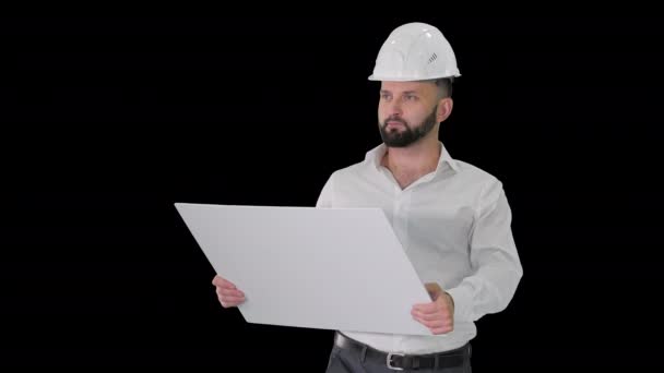 Muž inženýr procházející v helmě při pohledu na projekt rekonstrukce, Alpha Channel