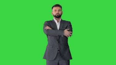 Sakallı, bıyıklı, takım elbiseli, kendine güveni tam bir iş adamı Yeşil Ekran 'ın üzerinde duruyor, Chroma Key.