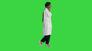 Yeşil ekranda yürürken konuşan Afrikalı Amerikalı kadın doktor, Chroma Key..