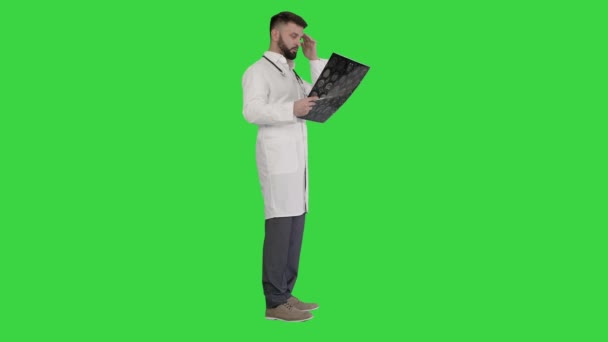 Médico lendo e revisando uma ressonância magnética em uma tela verde, Chroma Key. — Vídeo de Stock