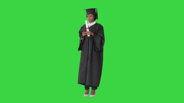 Feliz graduada afroamericana sosteniendo diploma y haciendo selfie en una pantalla verde, Chroma Key. — Vídeos de Stock