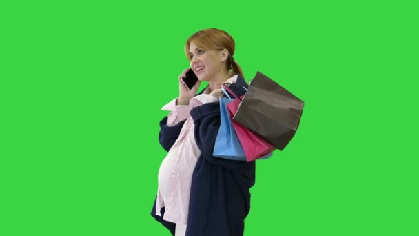 Felice donna incinta shopping e parlando per telefono che tiene borse su uno schermo verde, Chroma Key. — Video Stock