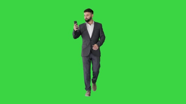 Homme d'affaires marche et faire un appel vidéo sur un écran vert, Chroma Key. — Video