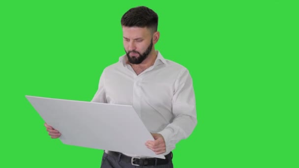 Podnikatel kráčí a dívá se na plán na zelené obrazovce, Chroma Key. — Stock video