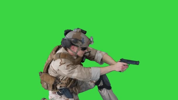 Soldat schießt aus Pistole kniend auf Green Screen, Chroma Key. — Stockvideo