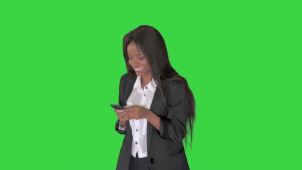 Rindo afro-americano feminino mensagens de texto em seu telefone em uma tela verde, Chroma Key . — Vídeo de Stock