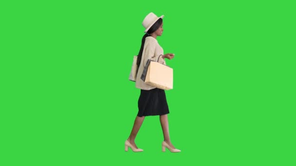 ハッピーアフリカ系アメリカ人女性の帽子とニットの歩行でショッピングバッグで緑の画面、クロマキー. — ストック動画