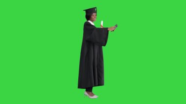 Mezun olmuş mutlu Afrikalı kadın diploması ve yeşil ekranda özçekim yapıyor, Chroma Key.