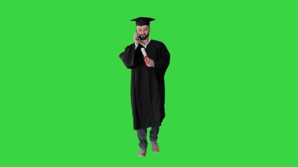 Examen student promenader och ringa ett samtal på en grön skärm, Chroma Key. — Stockvideo