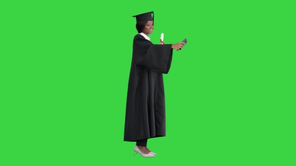 Glad afroamerikansk kvinna examen innehar diplom och göra selfie på en grön skärm, Chroma Key. — Stockvideo