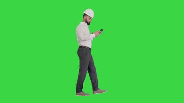 Engenheiro andando e usando smartphone em uma tela verde, Chroma Key . — Vídeo de Stock