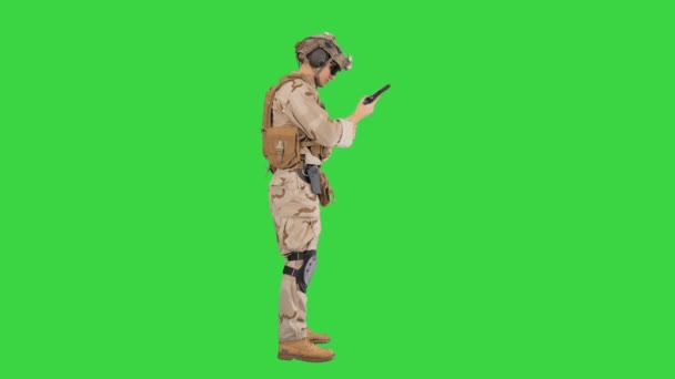 Joven con uniforme militar revisando pistola de revólver en una pantalla verde, Chroma Key . — Vídeos de Stock