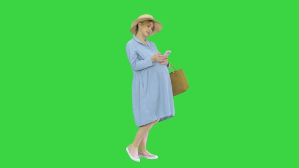 Mujer embarazada en el noveno mes usando un teléfono inteligente en una pantalla verde, Chroma Key. — Vídeos de Stock