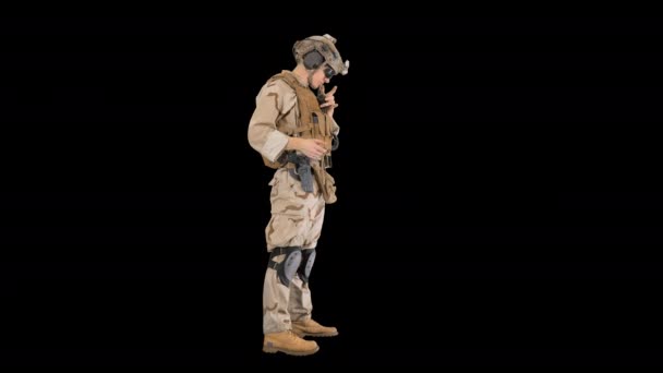 Солдат стоит и разговаривает по радио, Альфа-канал — стоковое видео