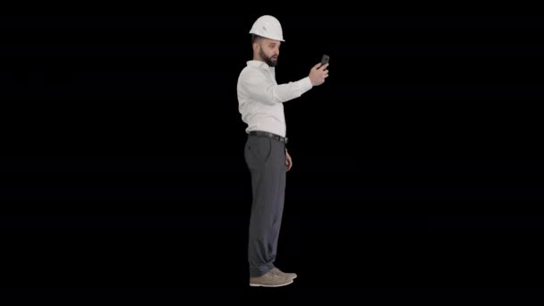 Man engineer wearing protecting safety helmet and shirt making video call, Alpha Channel — Stock Video