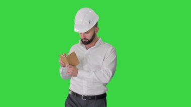 Formalite içinde kendine güvenen olgun bir adam Yeşil Ekran 'a notlar yazıyor, Chroma Key..